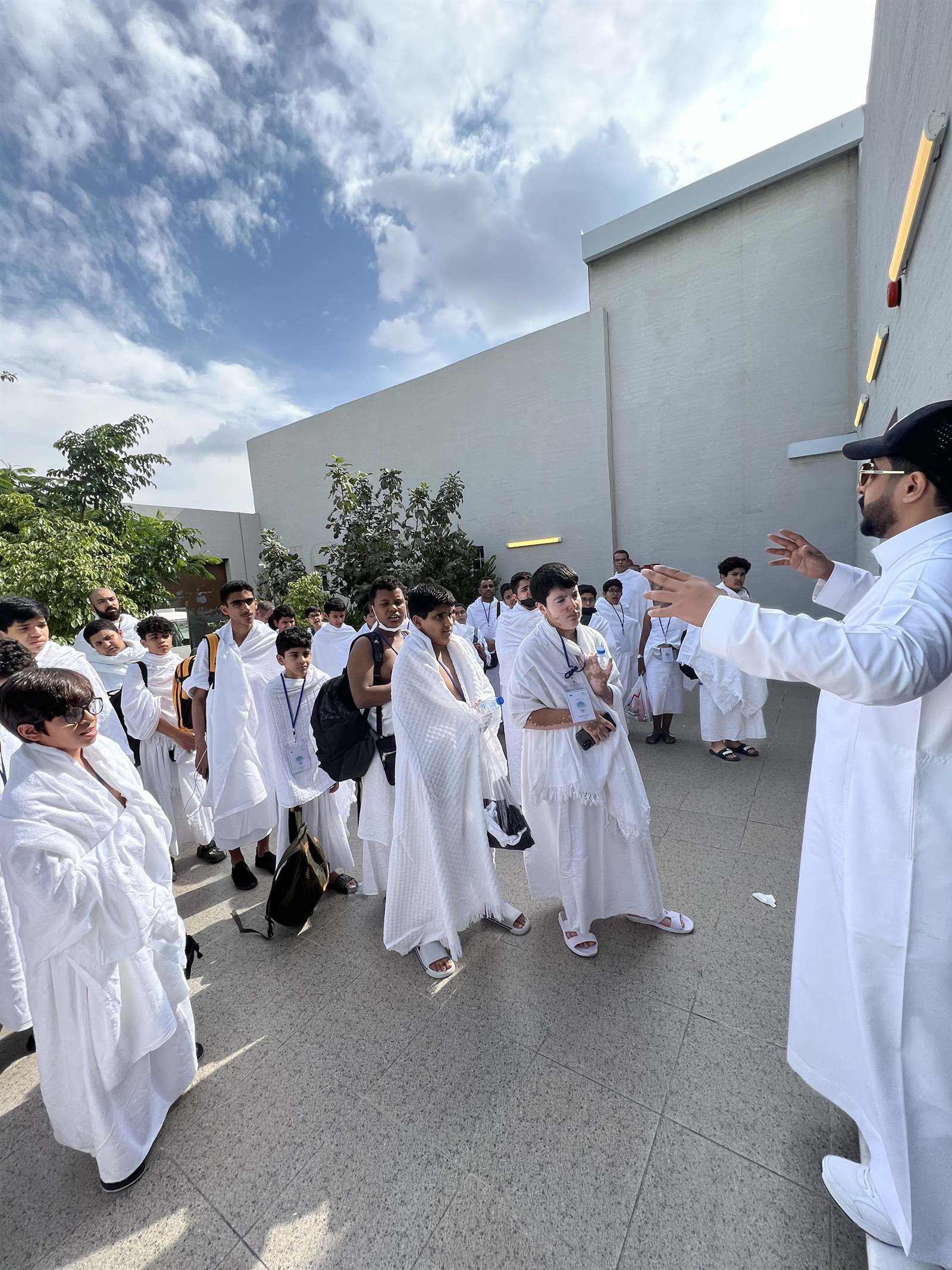 مشرف يوجّه مجموعة طلابية بالإحرام في مكة